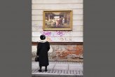A passer-by stops to look at one of the reproduction paintings displayed in the streets around the Russian Museum